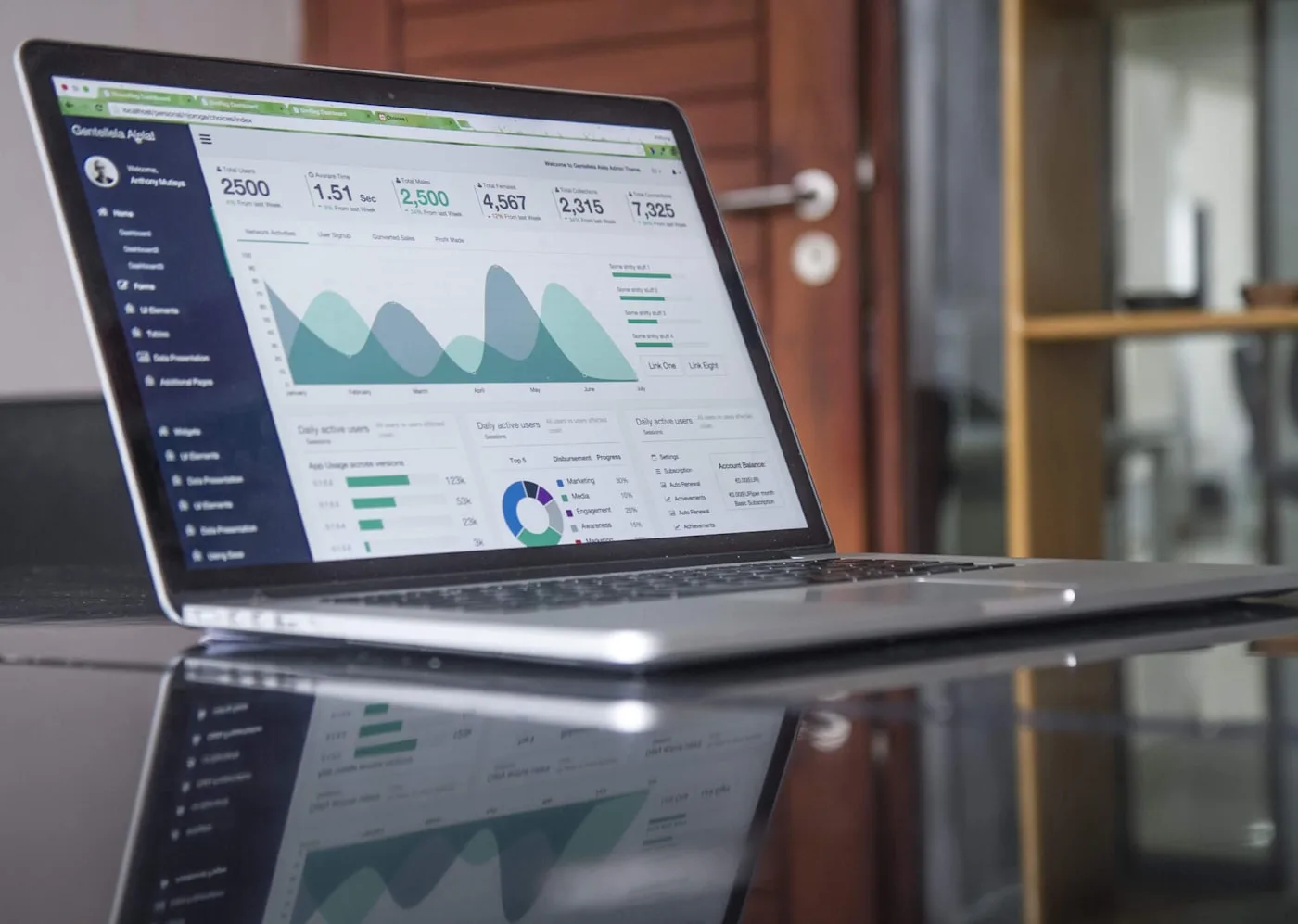Laptop mit Wachstums-Charts auf hellem Schreibtisch